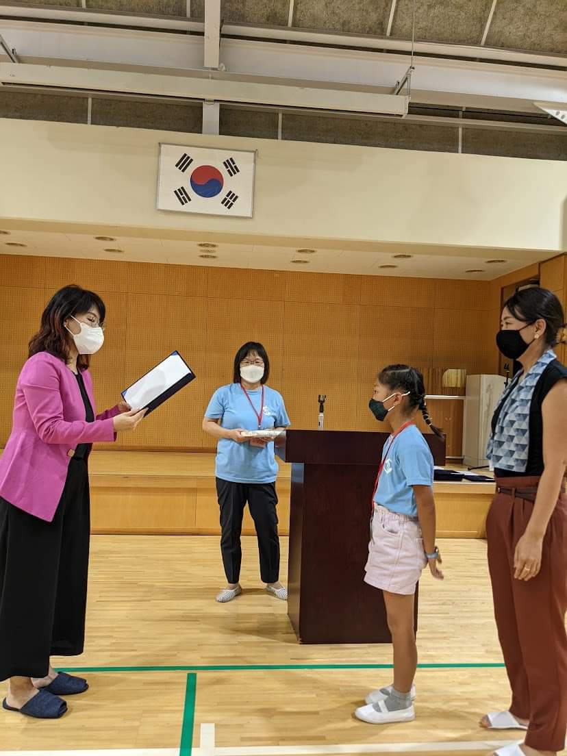 Стажер получает сертификат об окончании церемонии вручения дипломов в Токийской корейской школе