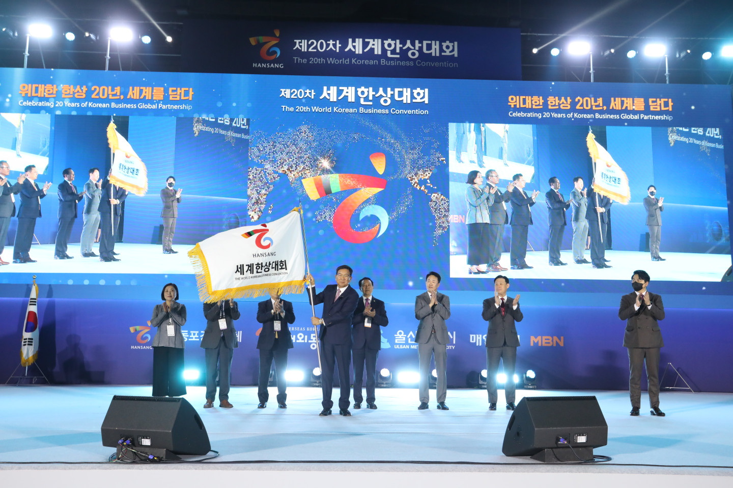 Ким Чжом Бэ машет корейским флагом, чтобы объявить об открытии 20-й Всемирной корейской бизнес-конвенции