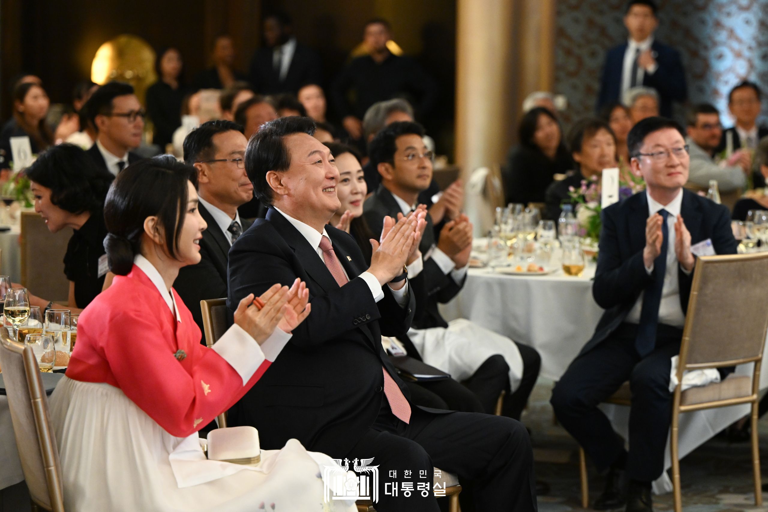 Президент РК Юн Сок Ёль и первая леди Ким Гон Хи 19 июня (по местному времени) аплодируют, наблюдая за выступлением на встрече с представителями корейской диаспоры в одном из отелей Парижа, Франция. / Фото: Канцелярия президента РК